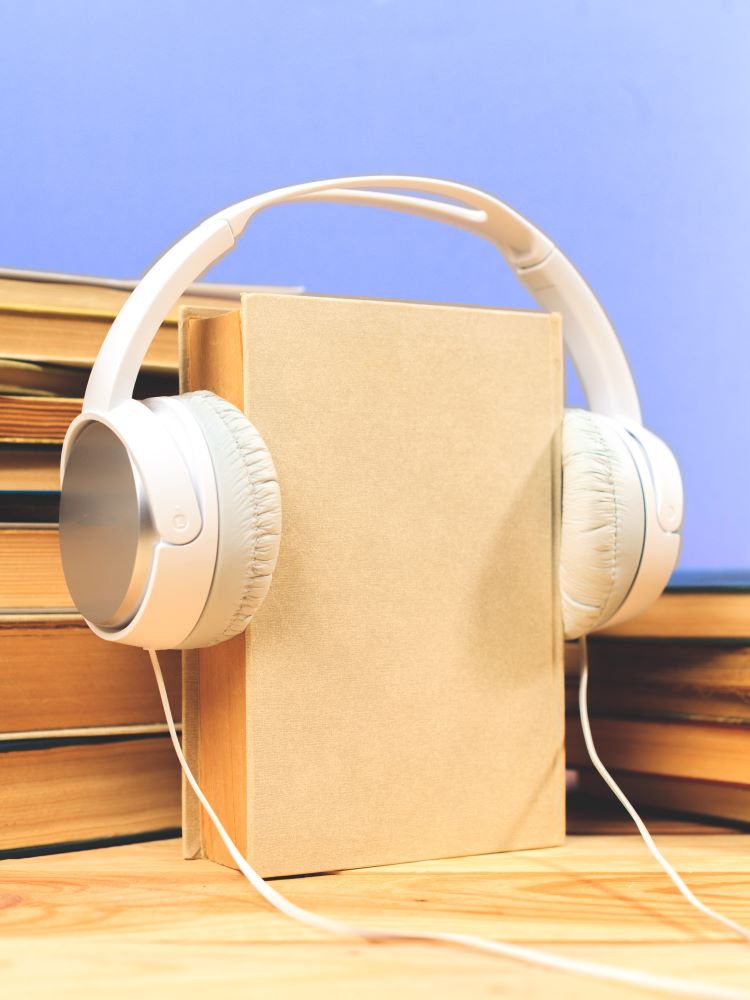 Audiobooks: image of two piles of books and one book with headphones on