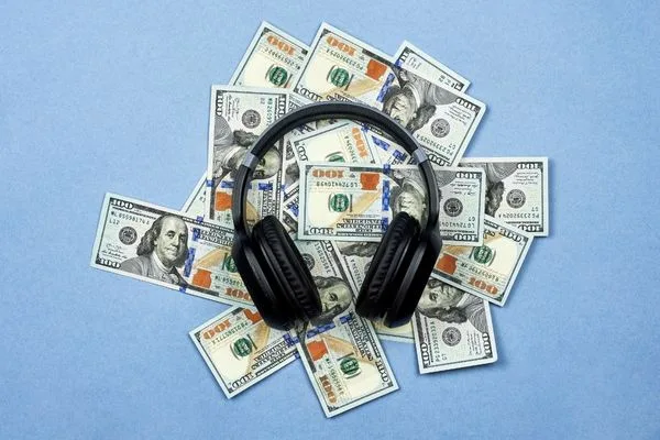 Black headphones lying on a stack of money
