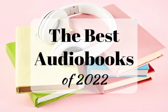 The Best Audiobooks of 2022 (background image showing a stack of colorful books and white headphones on top)