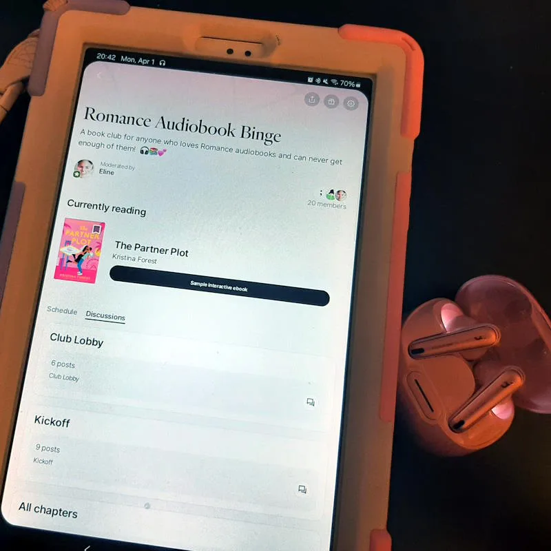 Photo of a tablet and earbuds, the screen shows the Fable app with the Romance Audiobook Binge book club and The Partner Plot, my audiobook recommendation for April